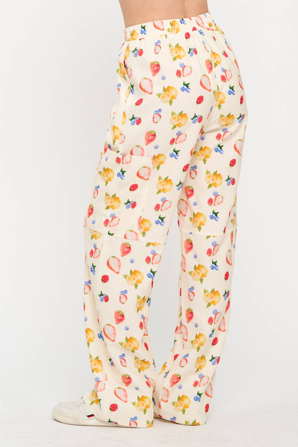 Back side view of berry wide-leg cargo pants with an elastic waistband, showcasing the lightweight fabric and vibrant fruity print.