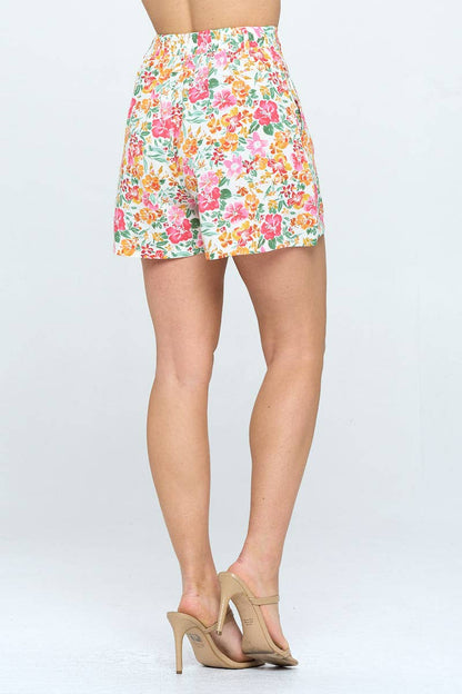 A model showcasing the back of high-waisted floral shorts with a tropical flower print, revealing the elastic waistband and relaxed fit.