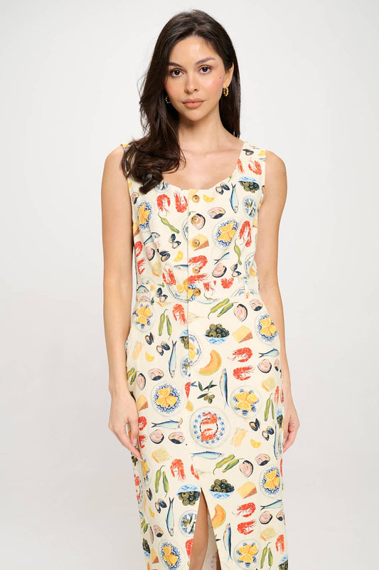 A model wearing the Mediterranean Delights Midi Dress, a sleeveless, square-neck midi dress with a seafood and fruit print, featuring side pockets.